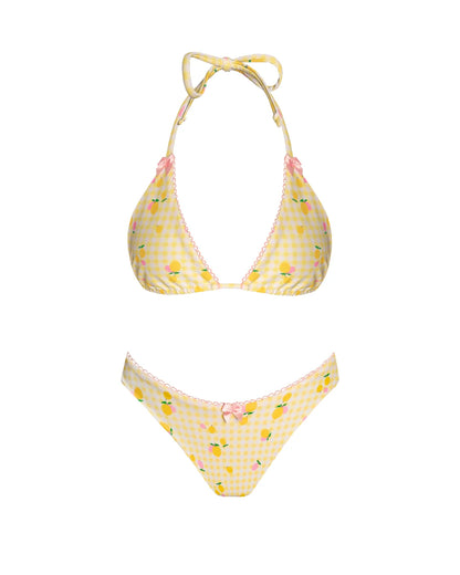 This image features a charming high-cut bikini bottom, bathed in a pastel yellow gingham pattern speckled with ditsy pink and yellow lemons. The bottoms are accented with pink lace trim and a playful pink bow at the front, adding a touch of sweetness to the design.